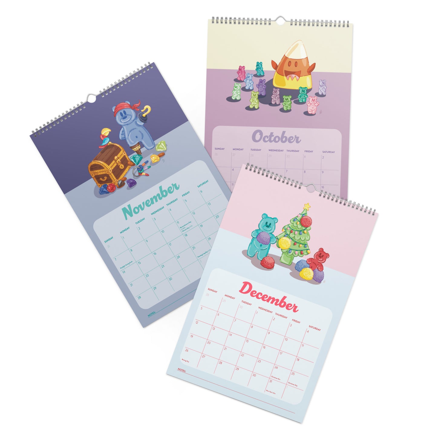 Three spiral-bound wall calendars shown at an angle on a white background, each featuring a different month (November, October, and December) with colorful cartoon gummy bear illustrations and pastel-colored page designs.
