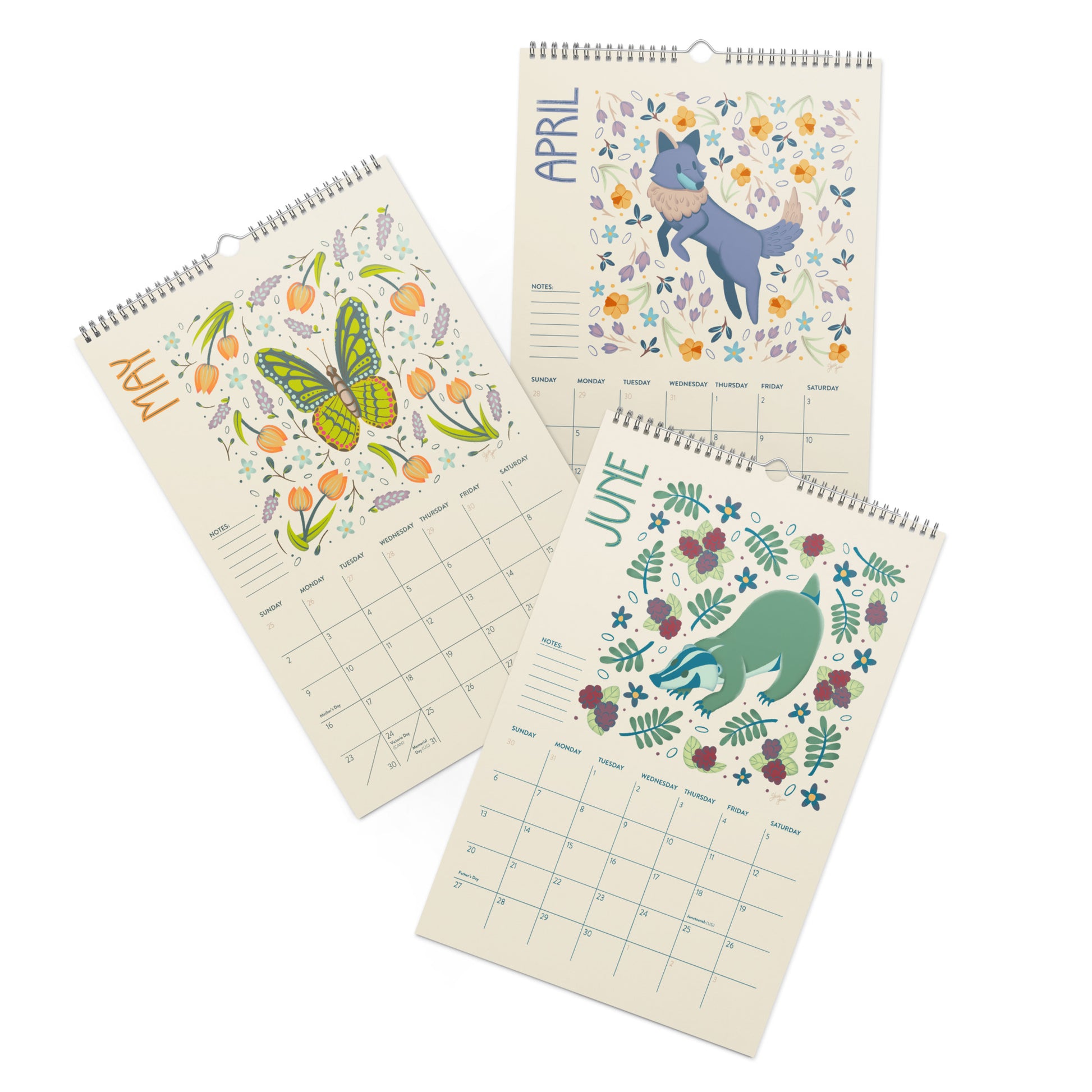 Three spiral-bound wall calendars fanned out on a white background, showing May, April, and June pages with colorful animal and floral illustrations on cream paper.  A 2027 wall calendar featuring colourful folk-art animal illustrations displayed in a flat lay. Wire-bound with premium thick paper, this illustrated monthly calendar showcases vibrant artwork for each month. Ideal for shoppers looking for a 2027 wall calendar