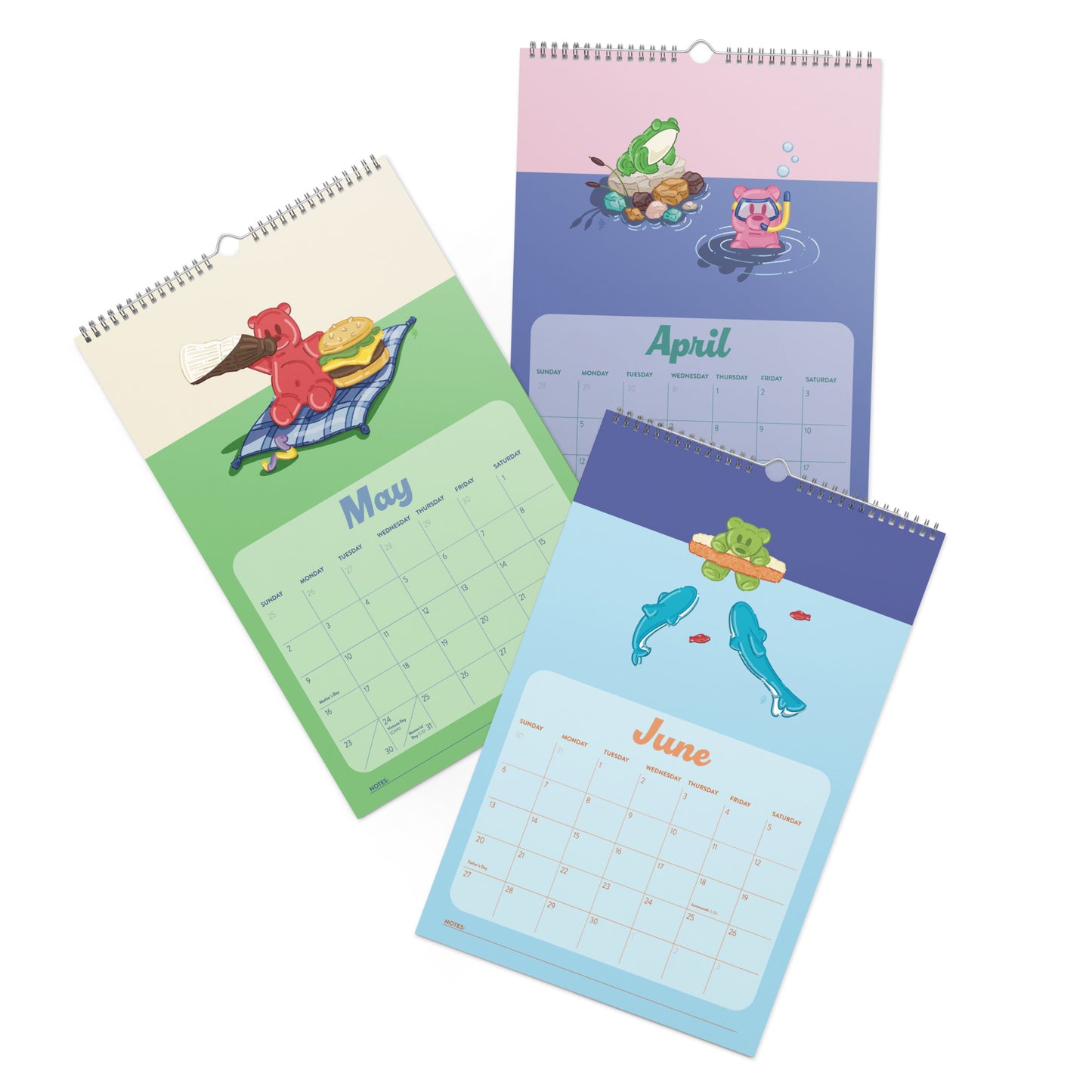 Three spiral-bound monthly calendar pages with colorful cartoon illustrations, showing May, April, and June layouts on a white background.