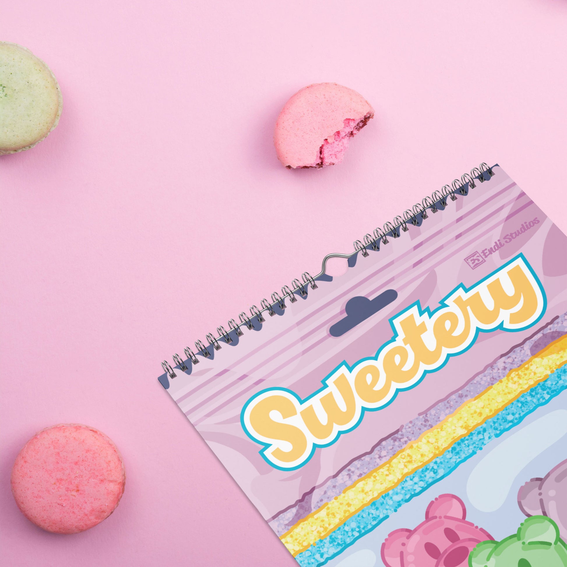 A spiral-bound 2027 wall calendar titled 'Sweetery' by Endi Studios and illustrated by Heidi Leduc, styled on a pink background with pink macarons.