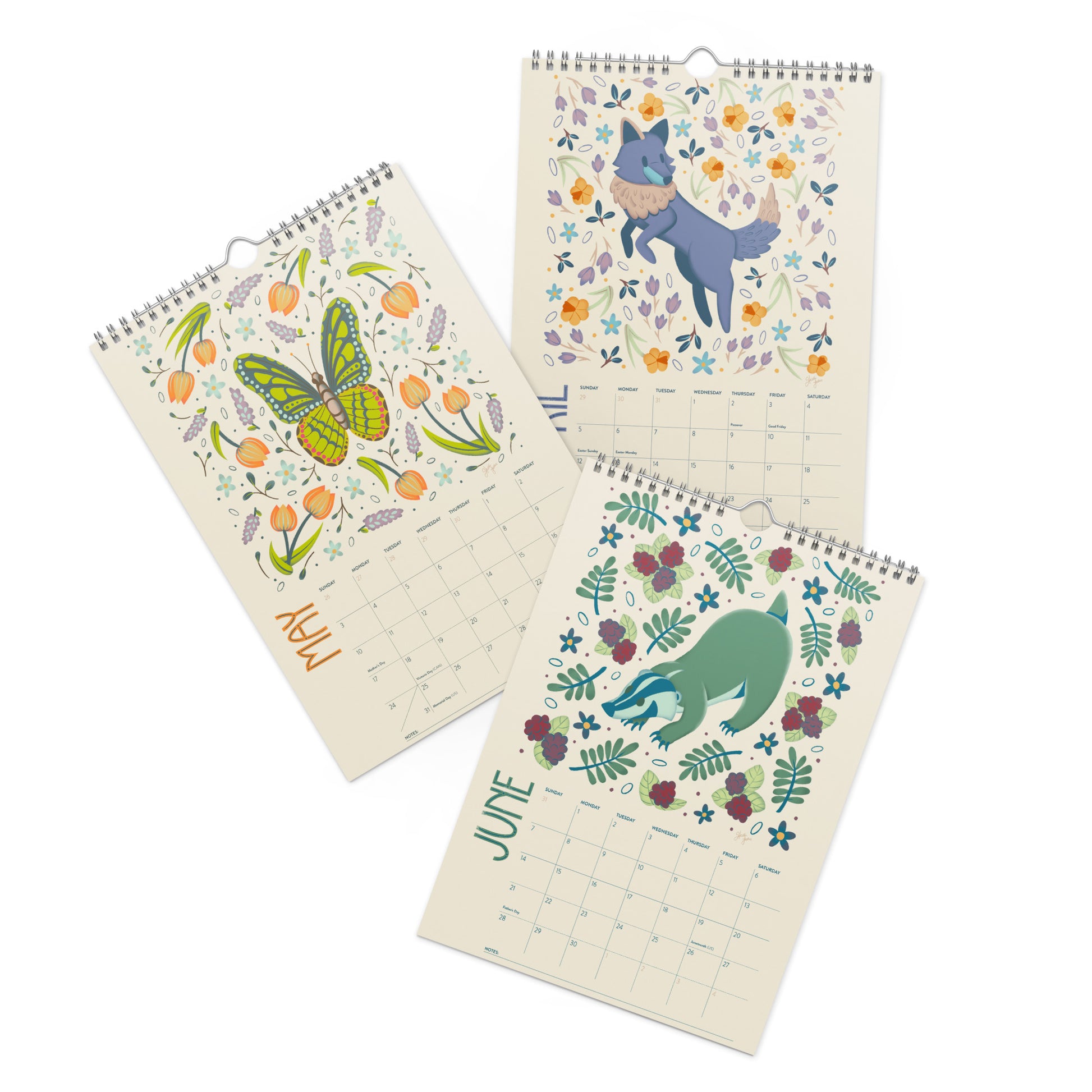A 2026 wall calendar featuring colourful folk-art animal illustrations displayed in a flat lay. Wire-bound with premium thick paper, this illustrated monthly calendar showcases vibrant artwork for each month. Ideal for shoppers looking for a 2026 calendar, animal art calendar, home décor calendar, or unique artist-designed wall calendar.