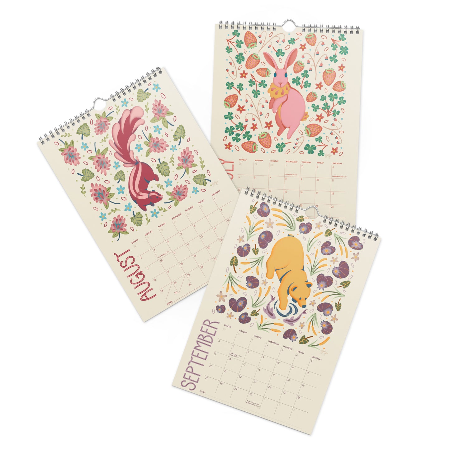 A 2026 wall calendar featuring colourful folk-art animal illustrations displayed in a flat lay. Wire-bound with premium thick paper, this illustrated monthly calendar showcases vibrant artwork for each month. Ideal for shoppers looking for a 2026 calendar, animal art calendar, home décor calendar, or unique artist-designed wall calendar.