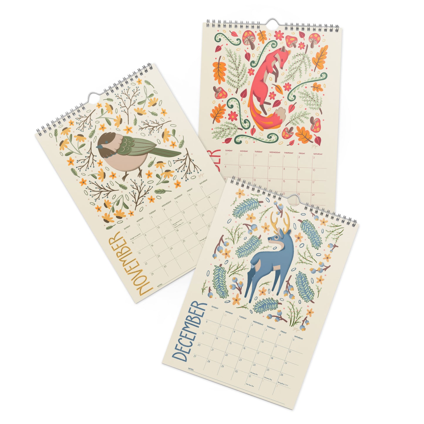 A 2026 wall calendar featuring colourful folk-art animal illustrations displayed in a flat lay. Wire-bound with premium thick paper, this illustrated monthly calendar showcases vibrant artwork for each month. Ideal for shoppers looking for a 2026 calendar, animal art calendar, home décor calendar, or unique artist-designed wall calendar.